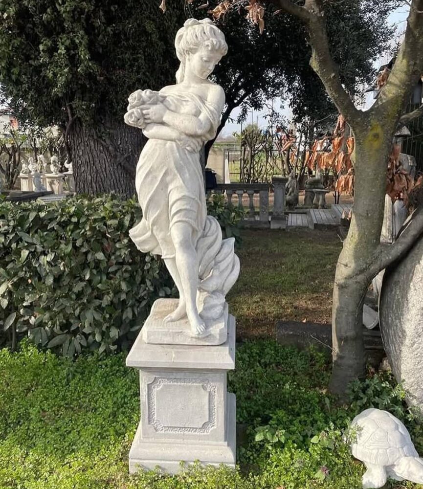 Statua da giardino in pietra raffigurante Eris con bouquet di fiori tra le braccia.